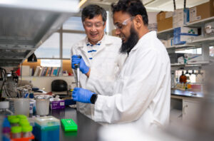 Jiyue Zhu and a student work in the laboratory.