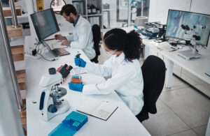 Technology, teamwork or collaboration in laboratory research, dropper test or dna science engineering in top view. Black woman, man or scientist in medical study, sample pipette or pharmacy medicine.