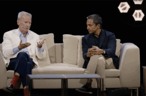 At the All-In Summit, Eric Schmidt is sitting on a couch next to Chamath Palihapitiya.