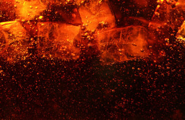 Detail of cola drink with ice cubes, fresh beverages background.