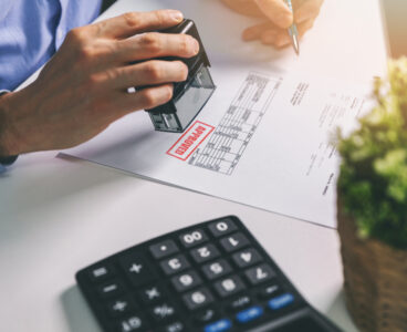 businessman accepting and stamping procurement bill in office