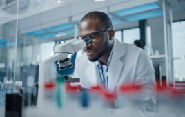 Modern Medical Research Laboratory: Portrait of Male Scientist Looking Under Microscope, Analysing Samples. Advanced Scientific Lab for Medicine, Biotechnology, Microbiology Development