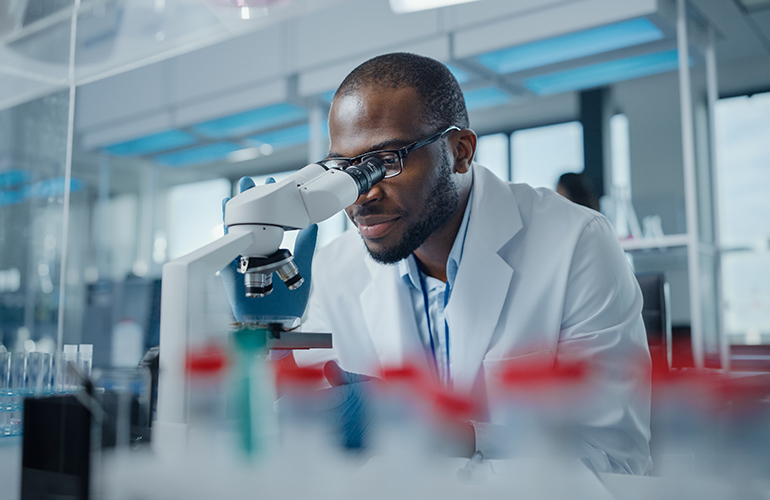 Modern Medical Research Laboratory: Portrait of Male Scientist Looking Under Microscope, Analysing Samples. Advanced Scientific Lab for Medicine, Biotechnology, Microbiology Development