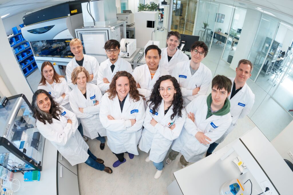 Members of Cradle's team at the company's lab in Amsterdam, surrounded by the automated liquid-handling and analytical equipment used to test the company's AI-designed protein sequences.
