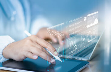 Doctor using digital tablet and laptop with AI dashboard holographic checklist overlay, analyzing KPI, workflow process, and compliance data visualization in modern healthcare digital environment.