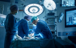 Surgical team operating under overhead lights in a modern operating room