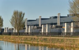 A data center campus with exhaust stacks beside a canal